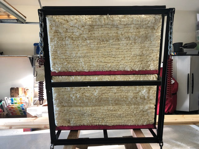 Attic lift gate lined with 2–3 inches of closed-cell foam insulation and red rubber weather stripping